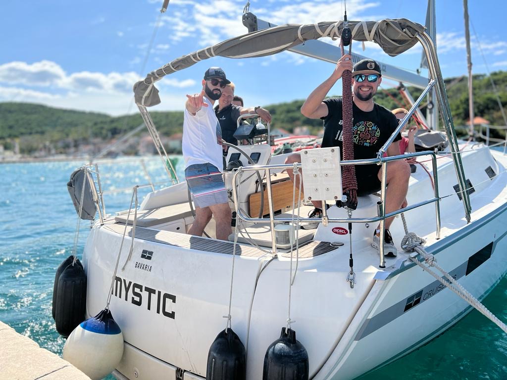 Crew on the stern of the training yacht MYSTIC near the coast