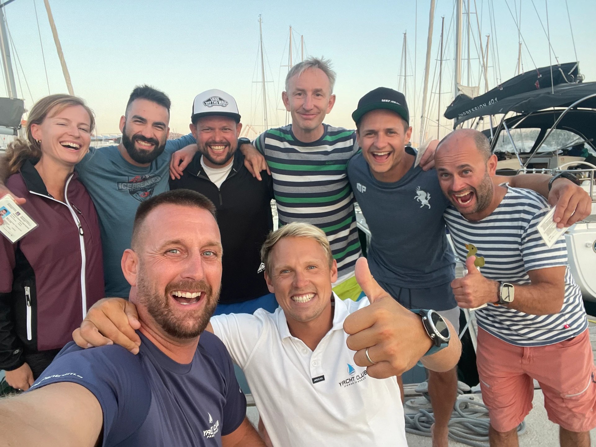 Course graduates with licenses by the boats in the marina
